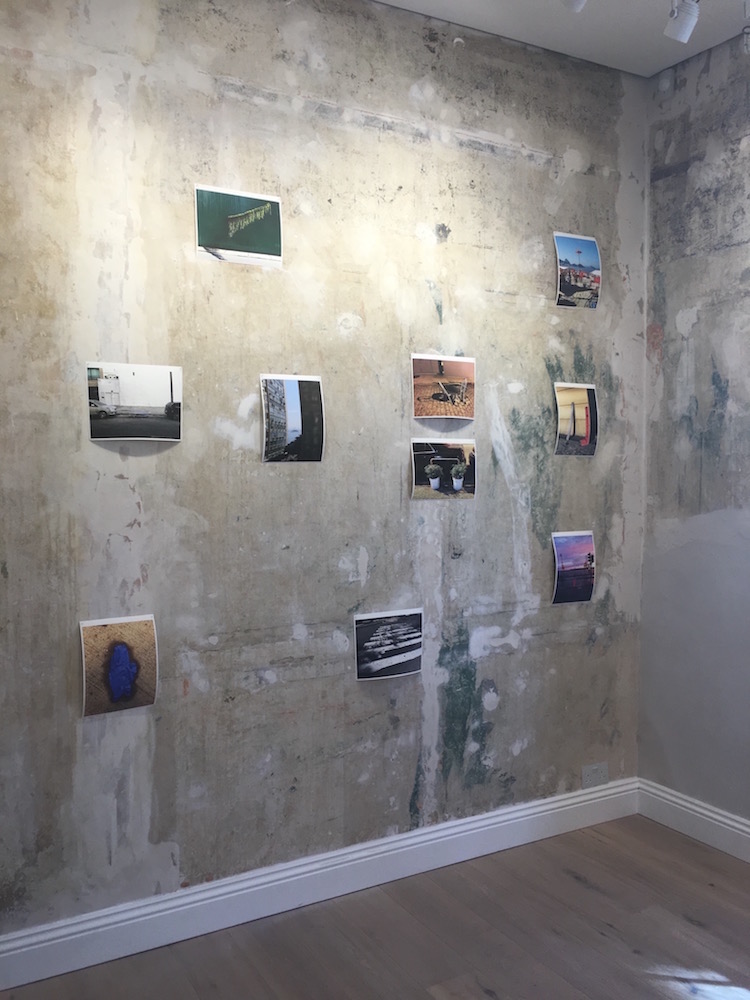 small photographic images on a rough painted wall by Marcos Chaves