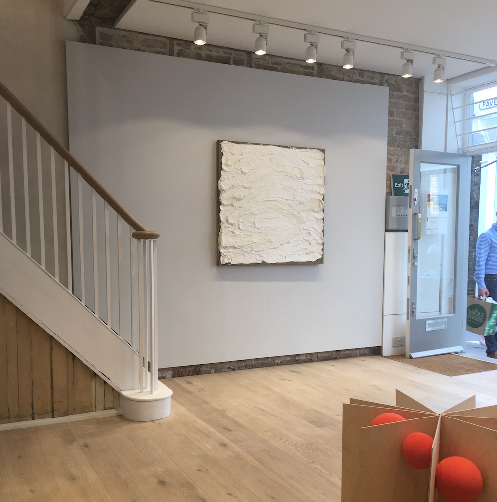 Ground floor installation view of the gallery with white painting by Marcia Thompson on the far wall