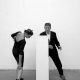 Black and white photo of artist Bruce McLean and his daughter designer Flora McLean dancing around an empty white plinth