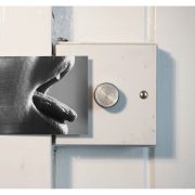 photograph of a mouth with tongue outstretched reaching towards a dimmer switch