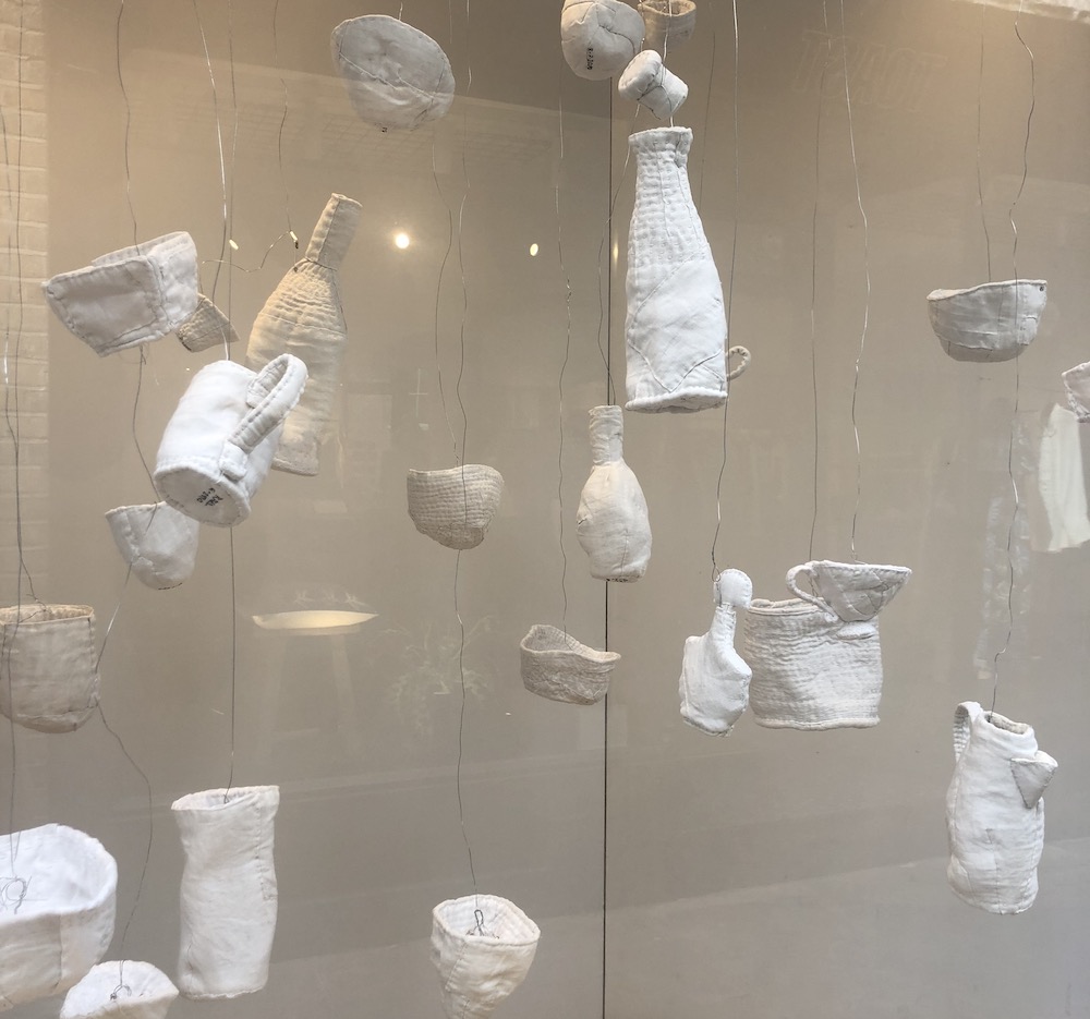 installation in the windows of One Paved Court using stitched soft sculpture ‘vessels’ - bowls, cups, bottles, a jug and a teapot made from felted wool blankets covered with vintage linen and damask