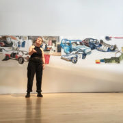 Amy Gillies, performance in front of drawings of cars