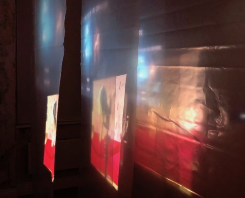 Projection in red and white across several layers of plastic sheeting